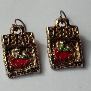 La Rage Pierced Earrings Gold Reads: SEEDS And Picture Of A Tomato On The Front